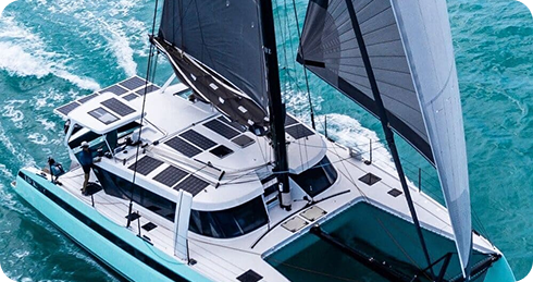 Sailing catamaran cutting through turquoise water